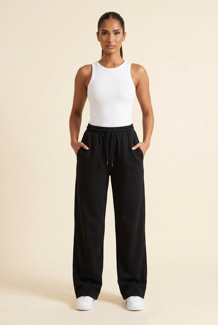 Kovelle wide leg joggers in black, hands in pockets, front view on model