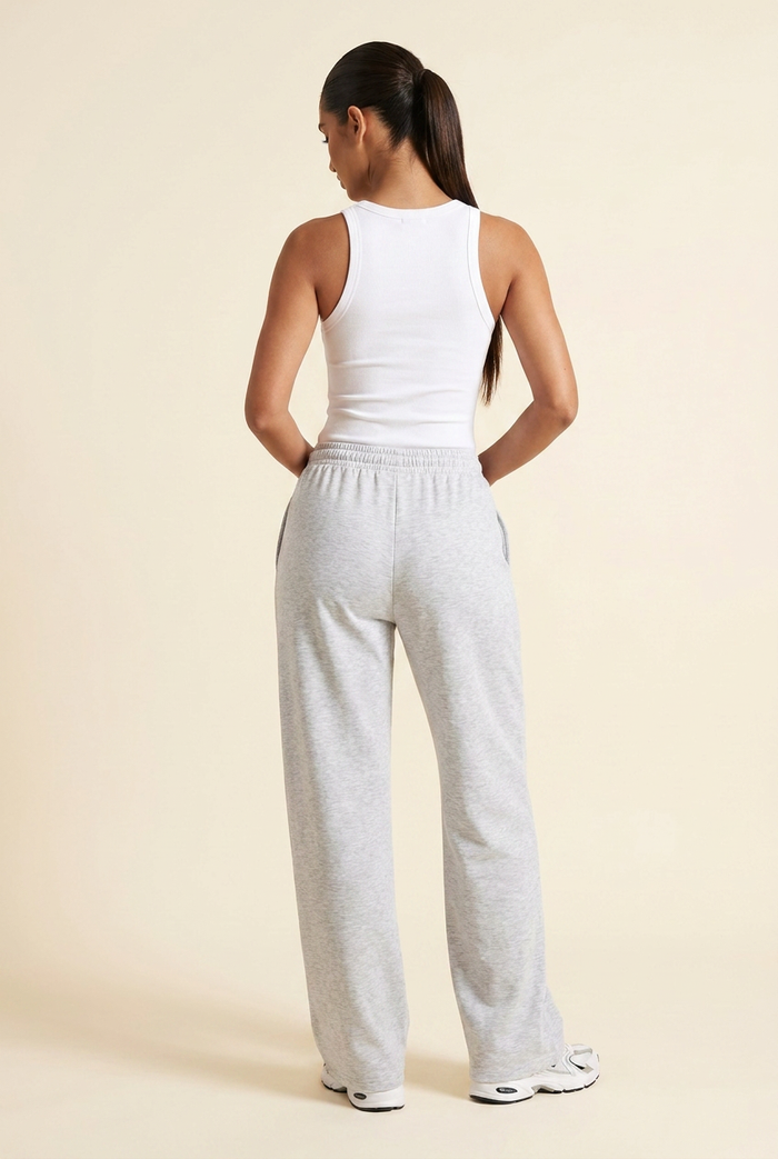 Kovelle wide leg joggers in light grey marl, back view with thumbs in the waistband, on model