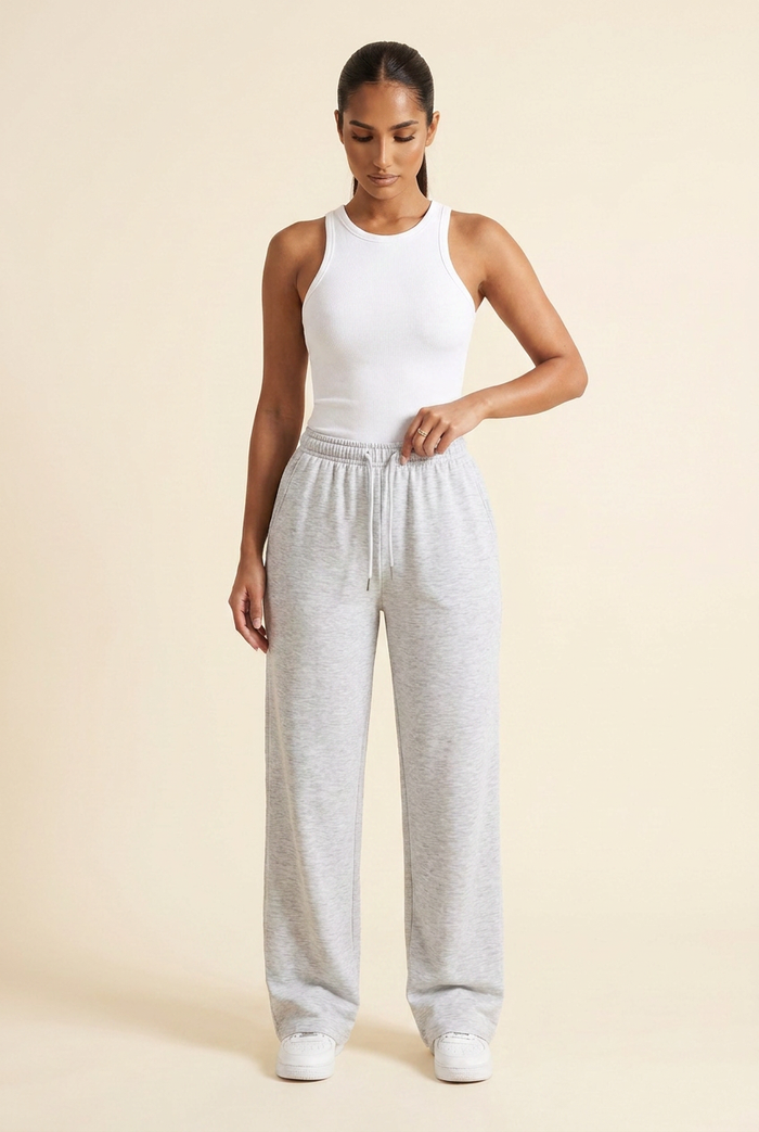 Kovelle wide leg joggers in light grey marl, pulling the drawstring at the waist, on model
