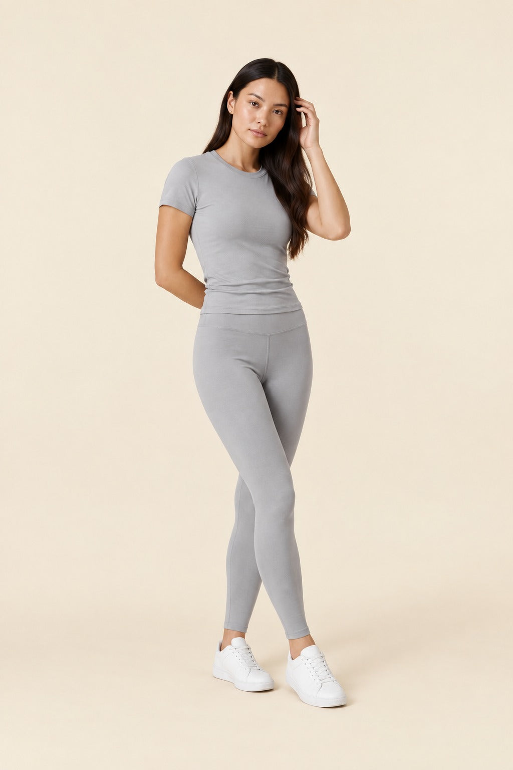 Kovelle round neck legging set in light grey, three quarter view with a hand in her hair, on model