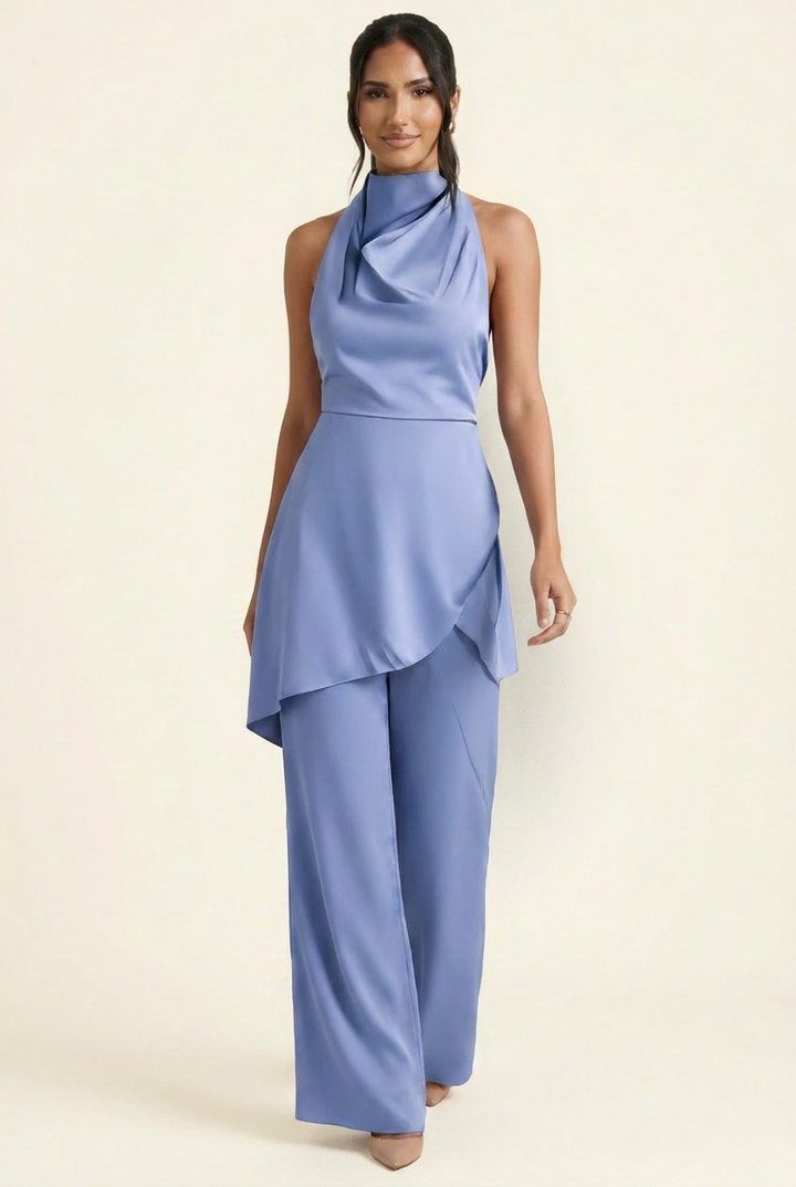 Kovelle satin cowl halter trouser co-ord in blue, walking shot with flowing trousers on model