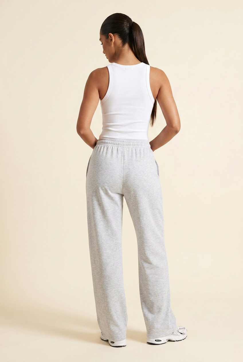 Kovelle wide leg joggers in light grey marl, back view with thumbs in the waistband, on model