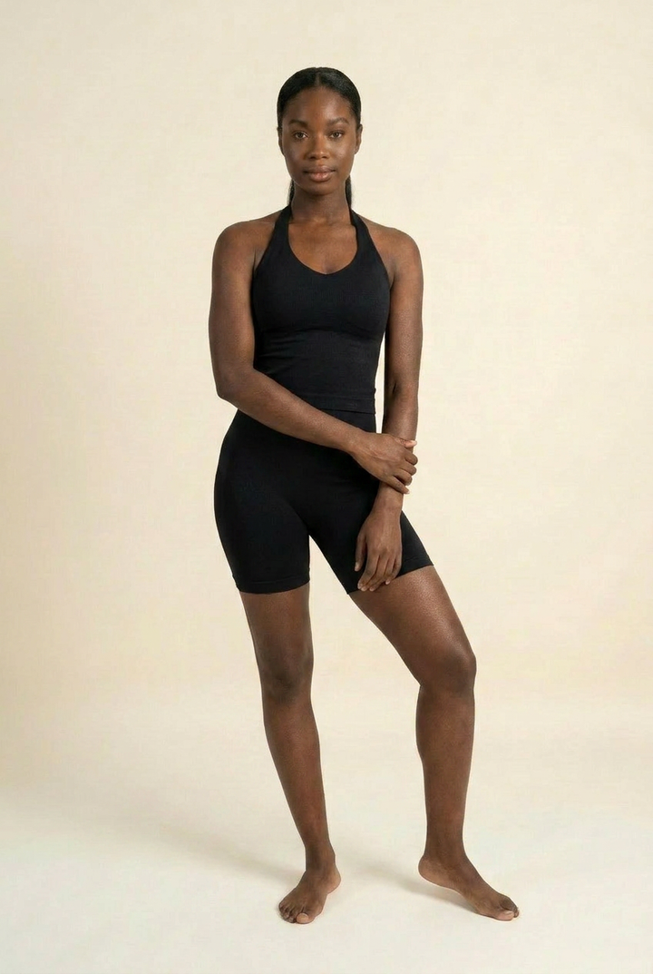 Kovelle halter vest gym set in black, vest and fitted shorts, arms crossed at waist, on model