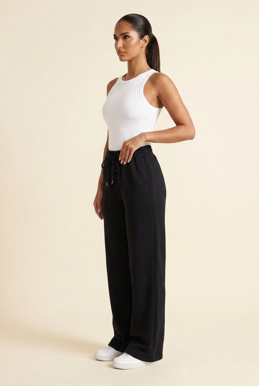 Kovelle wide leg joggers in black, side profile showing the loose wide leg, on model