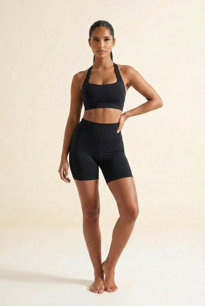 Kovelle seamless halter gym set in black, halter bra and scrunch shorts, three-quarter turn, on model