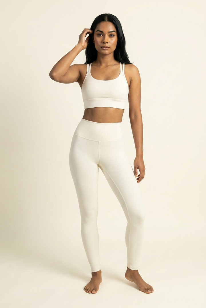 Kovelle cross back leggings set in ivory, scoop bra and high waist leggings, hand in hair, on model