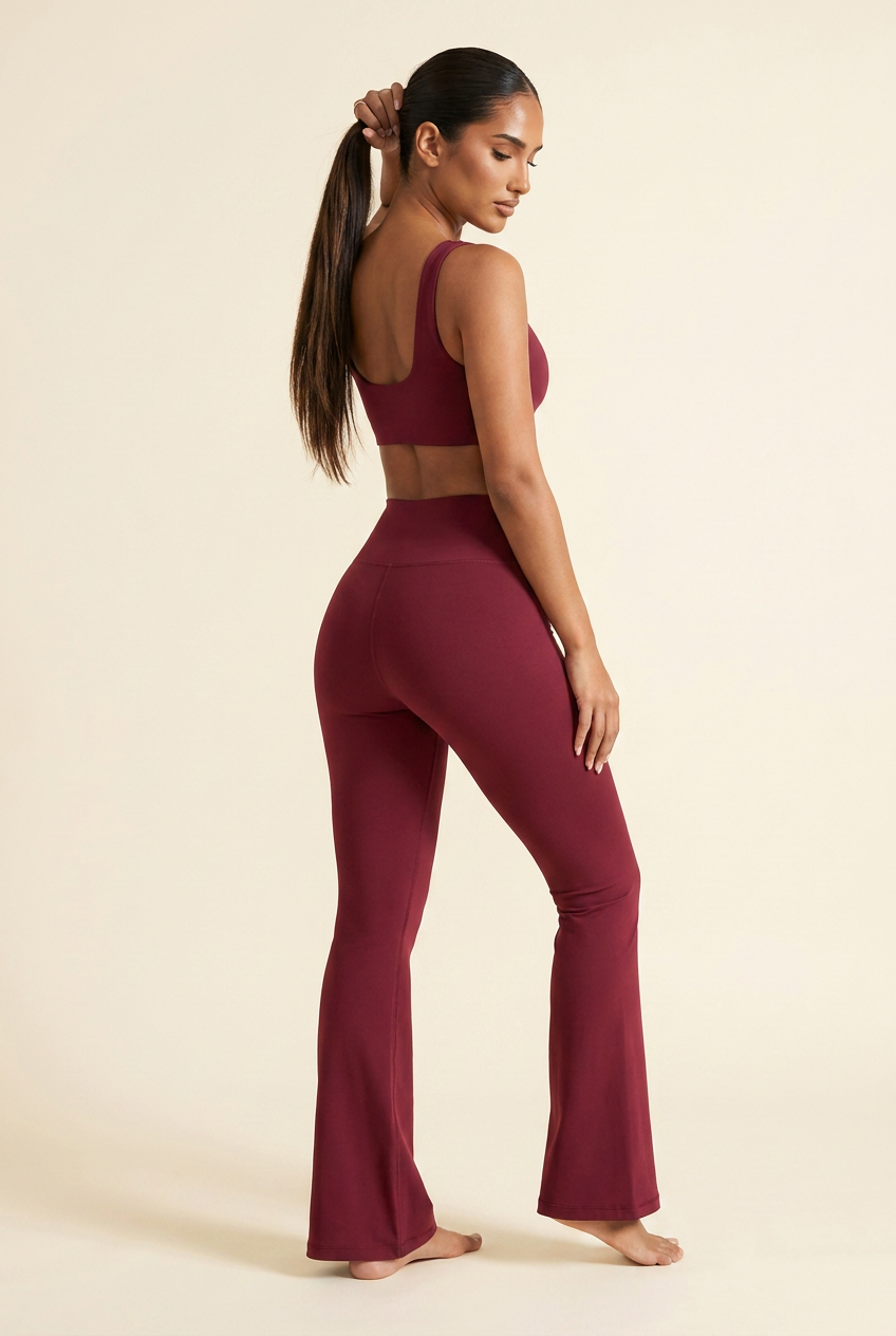 Kovelle high waist flare leggings in wine red, back three quarter view lifting her ponytail, on model