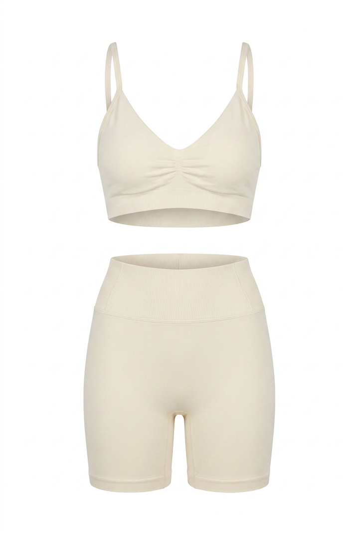The Kovelle Ruched Seamless Gym Set in ivory photographed on its own against a white background, showing the ruched bra and matching shorts