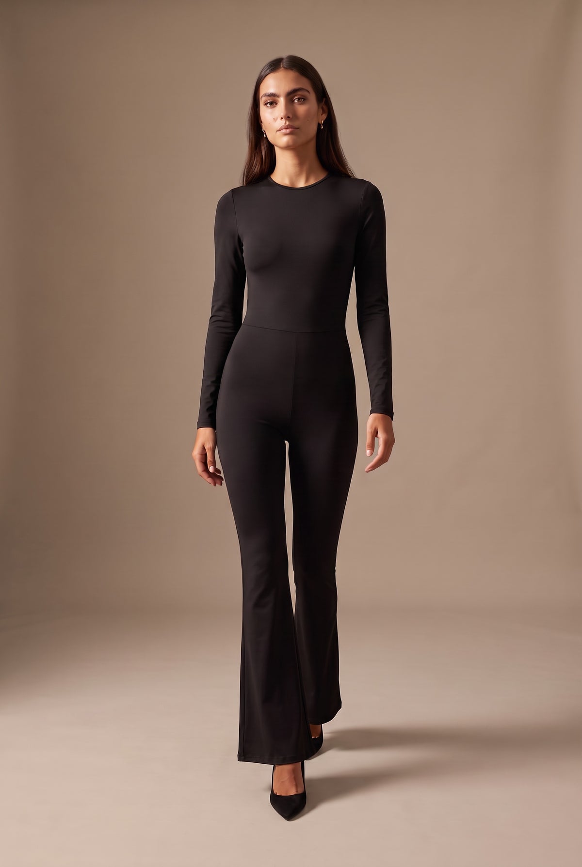 Kovelle open back flared jumpsuit in black, walking, full length on model