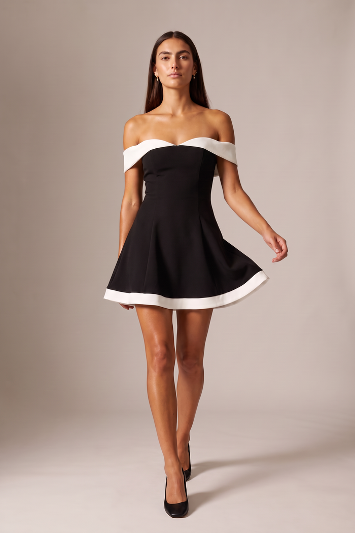 Full length studio shot of a model walking in the Kovelle Off Shoulder Contrast Flare Mini Dress