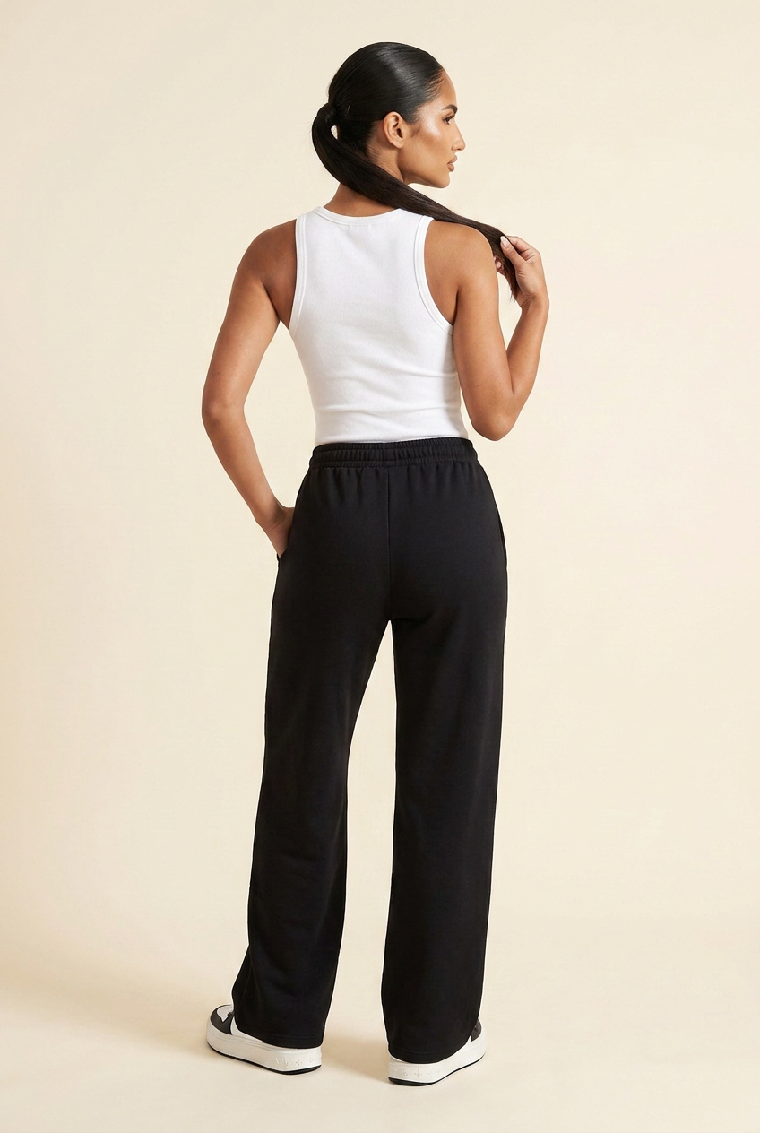 Kovelle wide leg joggers in black, back view with one hand in the pocket, on model