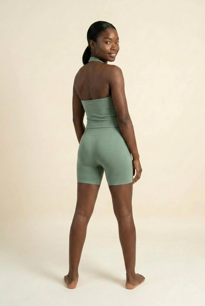 Kovelle halter vest gym set in sage, vest and fitted shorts, back view over shoulder, on model