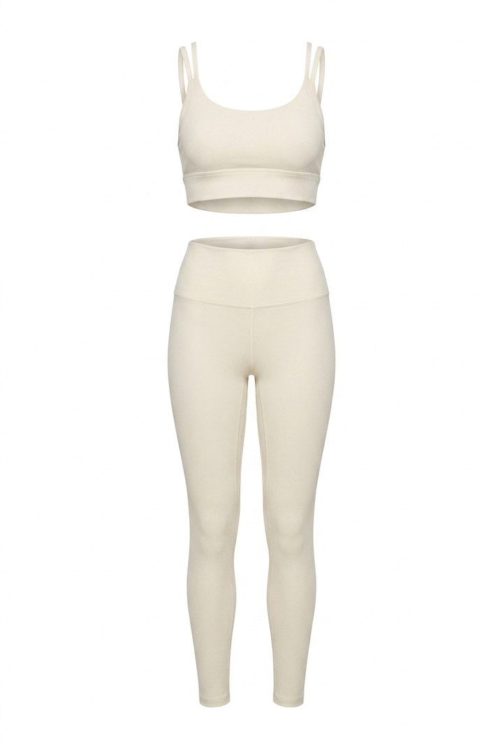 The Kovelle Cross Back Leggings Set in ivory photographed on its own against a white background, showing the bra and matching leggings